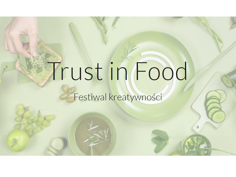 Zdjęcie promujące konkurs Trust in Food. Festiwal kreatywności. Na zdjęciu poza nazwą widoczne jedzenie, w tym jabłko, kanapka, ogórek zielony, winogrona, także talerz. Dominująca kolorystyka - zieleń. 